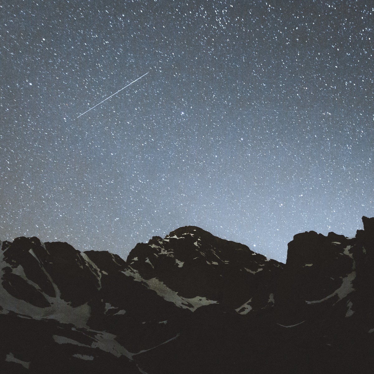 Mountain range with starry sky over it.