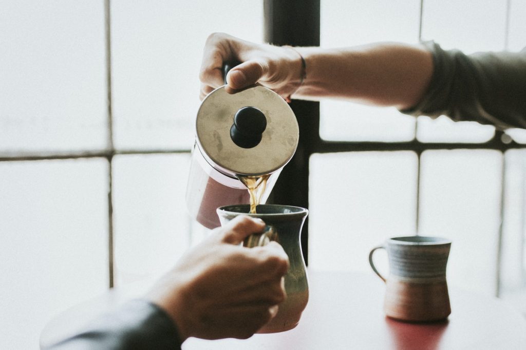 Coffee being poured into another person's cup, symbolizing the pouring of oneself into others. 