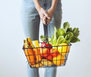 Young woman with fresh produce for vegan recipes.