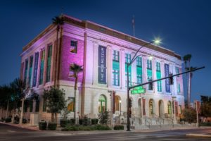The Mob Museum, lit up with bright, colorful lights at dusk.