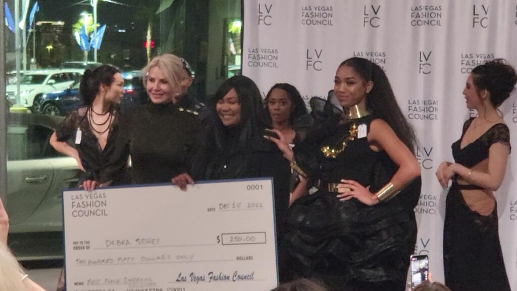 Debra Storey, founder of the Blazzian Collection, accepts the 2022 Las Vegas Fashion Council Award for the Little Black Dress competition in the Emerging Fashion Designer and Social Media Voting categories. 