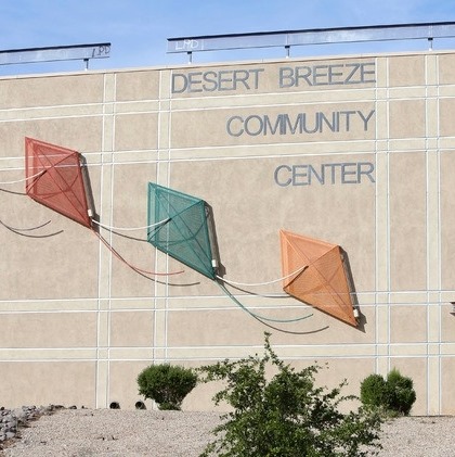 Photo of Desert Breeze Community Center. Beige building with red, green, and orange 3D kites on the outside. (From DBCC Facebook)