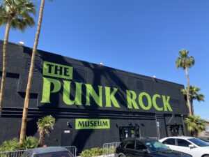 Front of The Punk Rock Museum, a large black painted building with lime green text.